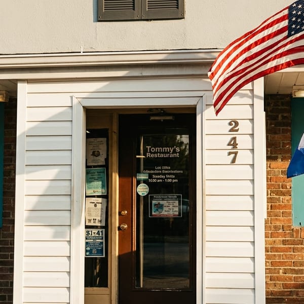 Tommy's Restaurant exterior with an American flag and a blue and white flag flying.